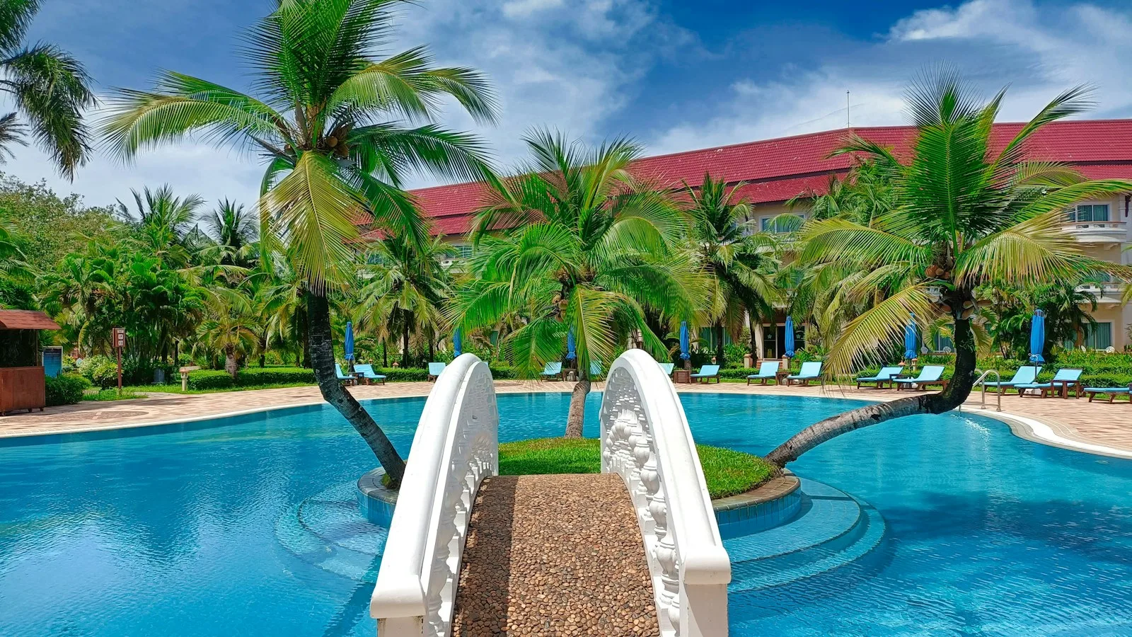 Famille avec enfants profitant d'une piscine d'hôtel entourée de végétation tropicale au Cambodge